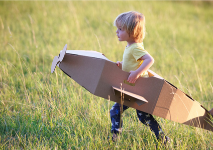 A child's imagination takes flight as they play in a cardboard box aeroplane, representing a moment of pure joy during a family move in Brisbane. This scene highlights the strength and versatility of Storage King's moving boxes, part of our complete range of quality packing supplies.
