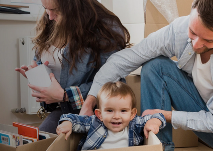 A happy family during a move, with their child playing in a cardboard box—a scene representing the many questions we've answered over the years. Our Advice and FAQ page draws on decades of experience to provide trusted, expert guidance for every step of your storage journey.
