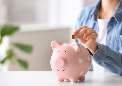 A person places a coin into a piggy bank, representing the simple and secure process of paying your account at Storage King. Use this page to easily make a payment for your self storage unit.