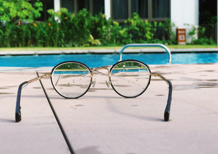 A pair of reading glasses rests beside a clear, calm pool, representing our commitment to transparency. This image introduces the Storage King terms and conditions, where every detail of our self storage agreement is put in clear focus for you.