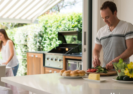 A happy Australian family is preparing a weekend BBQ in their spacious and tidy backyard. This image represents an improved, stress-free lifestyle, made possible by decluttering the family home using a residential self storage unit from Storage King.